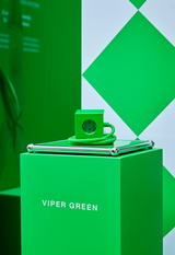 AVOLT power cube in Viper Green on pedestal with coiled braided cable and EU socket, modern studio display