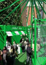 AVOLT BAR pop-up kiosk in green canopy with staff and visitors at an outdoor event
