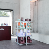 AVOLT chargers and power adapters displayed on metal shelving in a minimalist concrete museum shop.