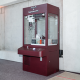 AVOLT x bauhaus-archiv maroon claw machine in museum showing boxed AVOLT products on display